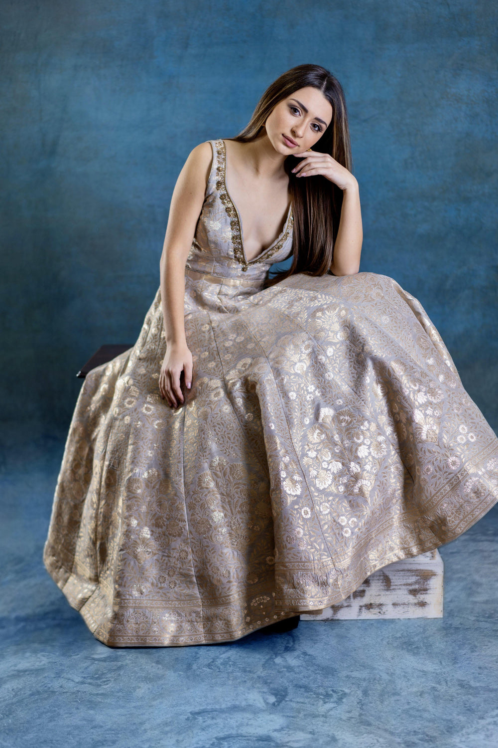 Jacquard silk A-line gown in gold with intricate woven patterns, deep plunge neckline, and hand embroidery.