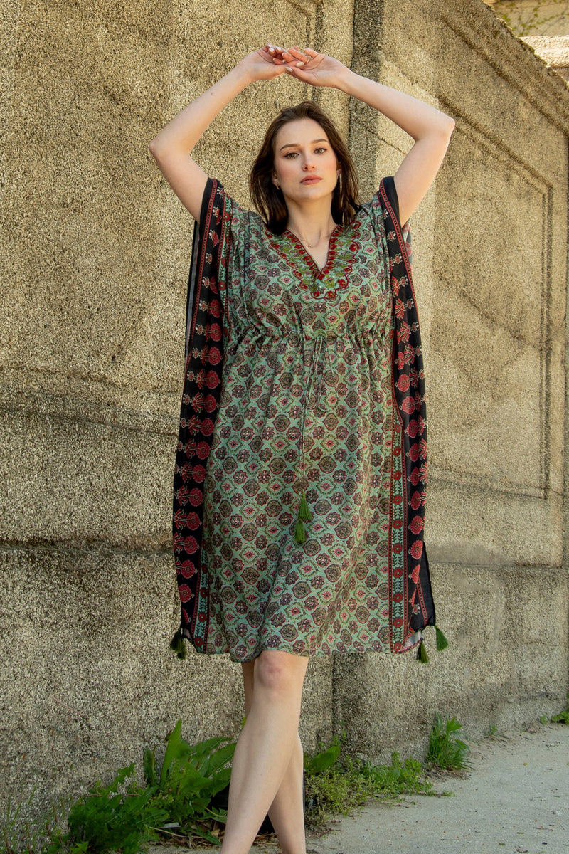 Woman in a green Ajrakh print muslin silk kaftan with embroidered V-neckline and drawstring waist.