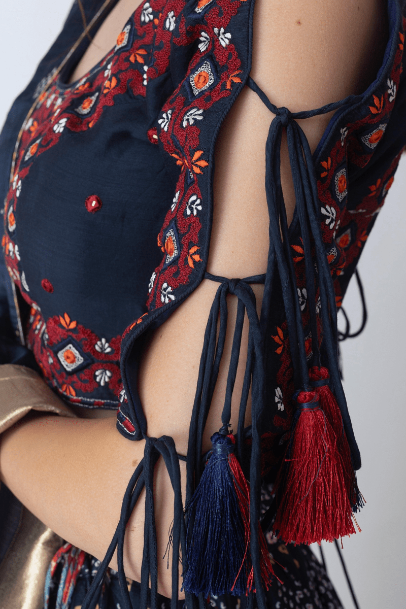 Navy silk blouse with red and white embroidery, tie-up sleeves, and tassels, perfect for Garba.
