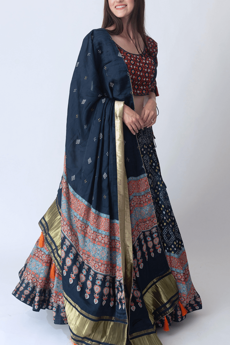 Woman in a navy Bandhani & Ajrakh print lehenga choli with a dramatic twirl, perfect for Garba.