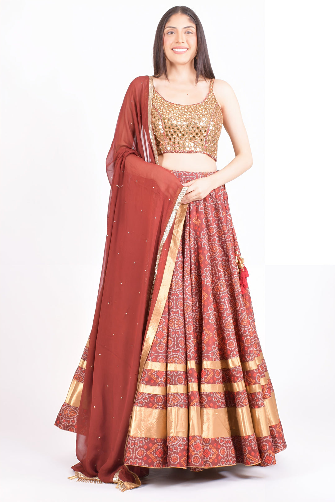 Woman in a red Bandhani print Chaniya Choli with a gold hand-embroidered blouse, perfect for Garba.