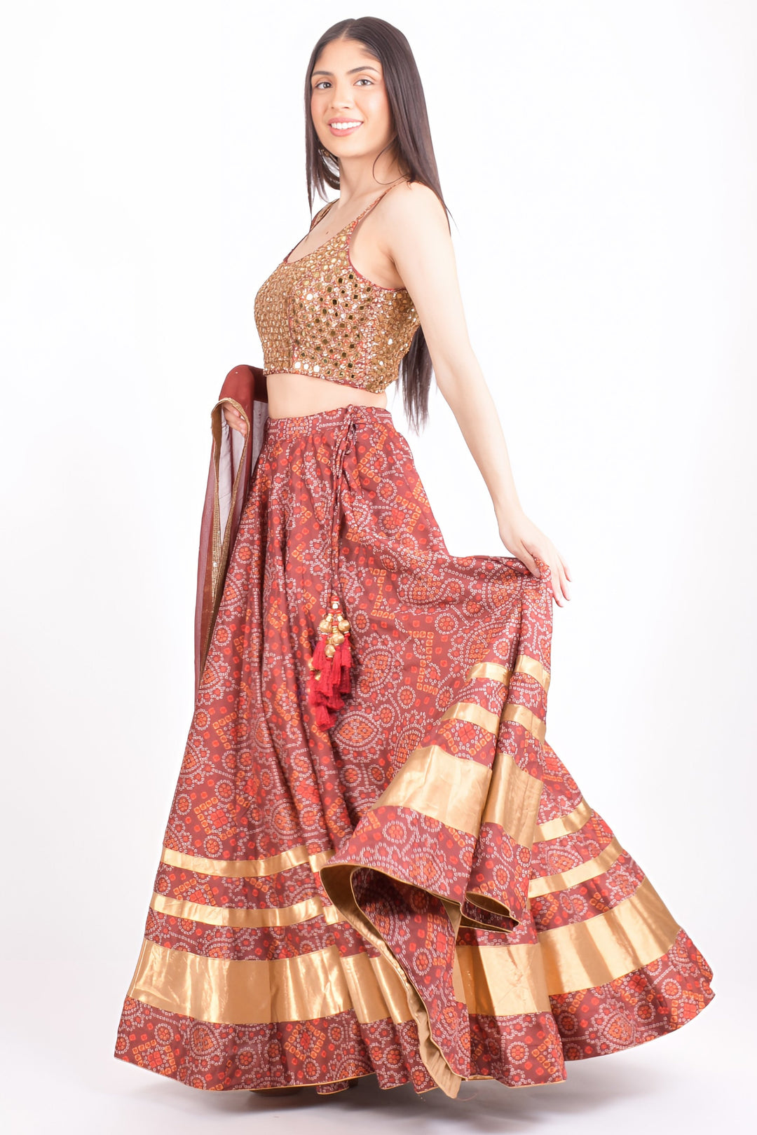 Woman in a red Bandhani print Chaniya Choli with a gold hand-embroidered blouse, perfect for Garba.