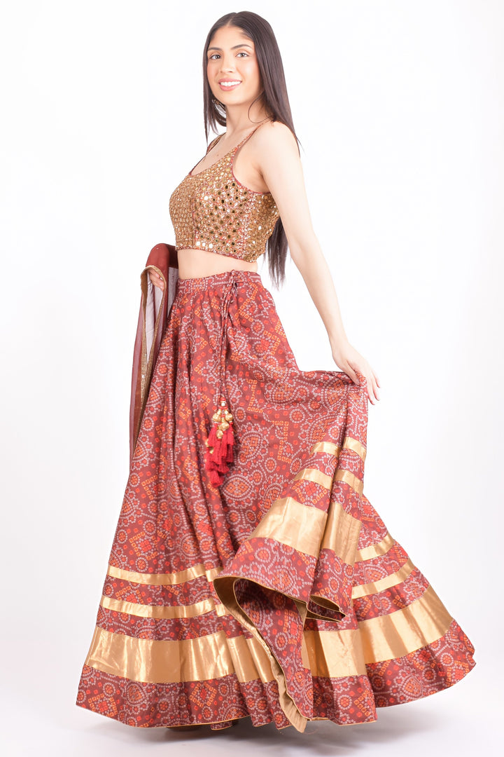Woman in a red Bandhani print Chaniya Choli with a gold hand-embroidered blouse, perfect for Garba.