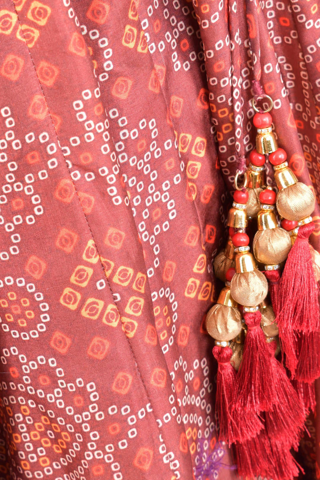 Bandhani print crape chaniya choli with red tassels, perfect for Garba styles.