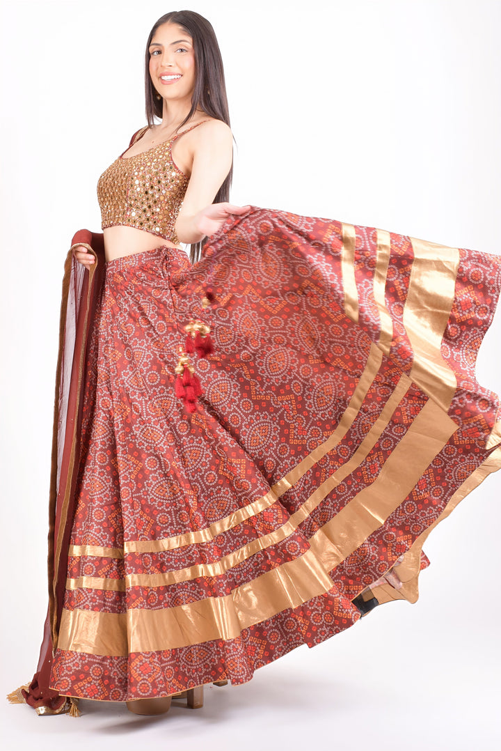 Woman in a red Bandhani print Chaniya Choli with a gold sequin blouse, twirling for Garba.
