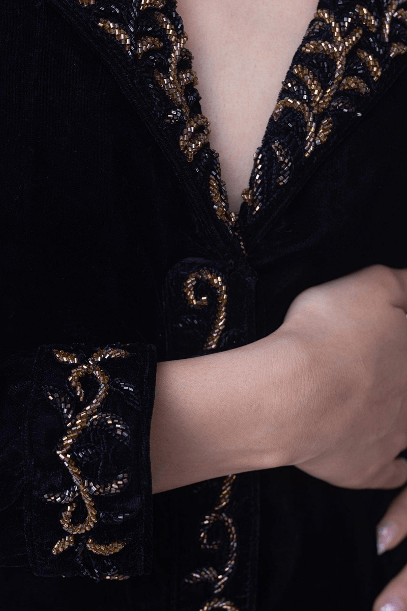 Black velvet blazer dress with intricate gold hand embroidery on collar, front closure, and sleeve border.