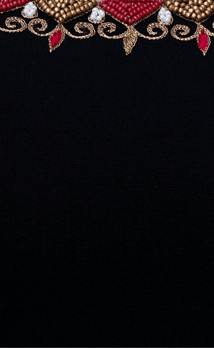 Close-up of black silk fabric with intricate gold, red, and white embroidered border.