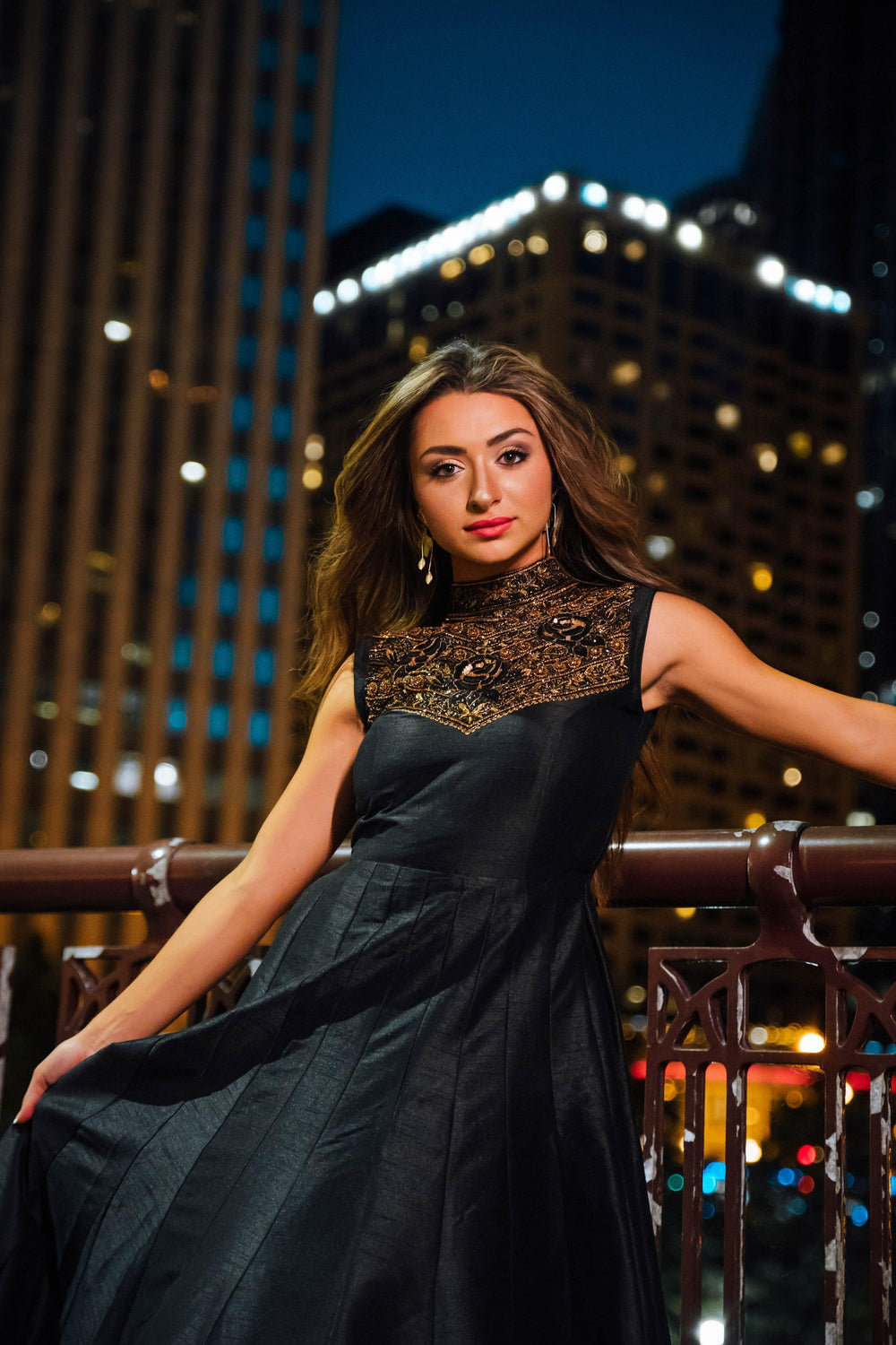 Black raw silk gown with intricate gold hand embroidery on the high neckline and torso.