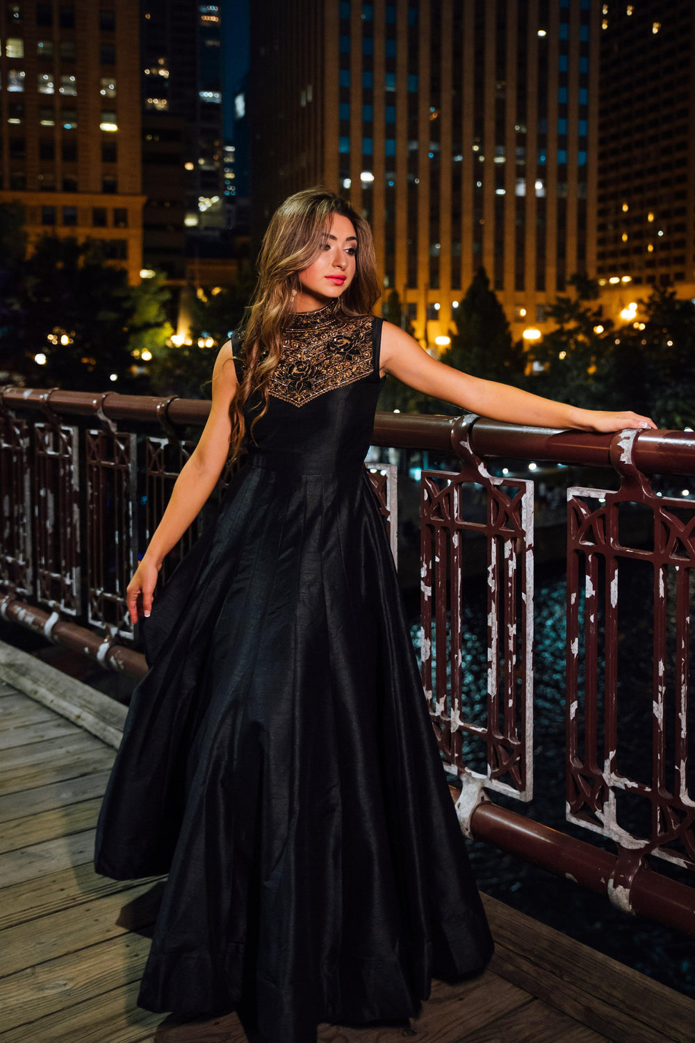 Black raw silk gown with intricate hand embroidery on a high neckline and torso.