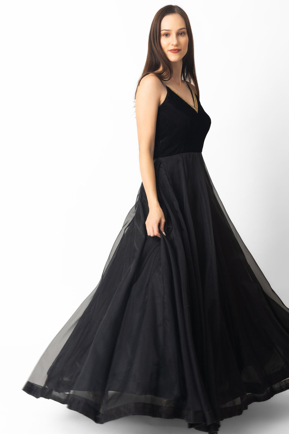 Black velvet and organza gown with hand-embroidered golden neckline, A-line silhouette.