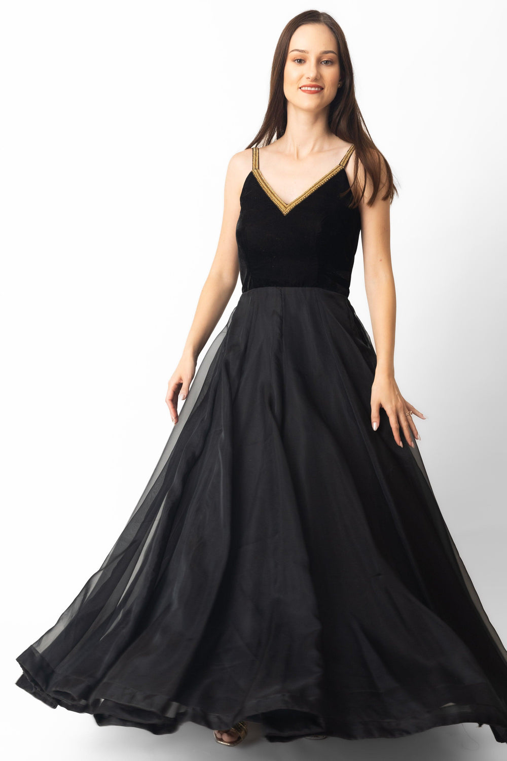 Black velvet and organza gown with golden hand-embroidered v-neckline and flowing A-line skirt.