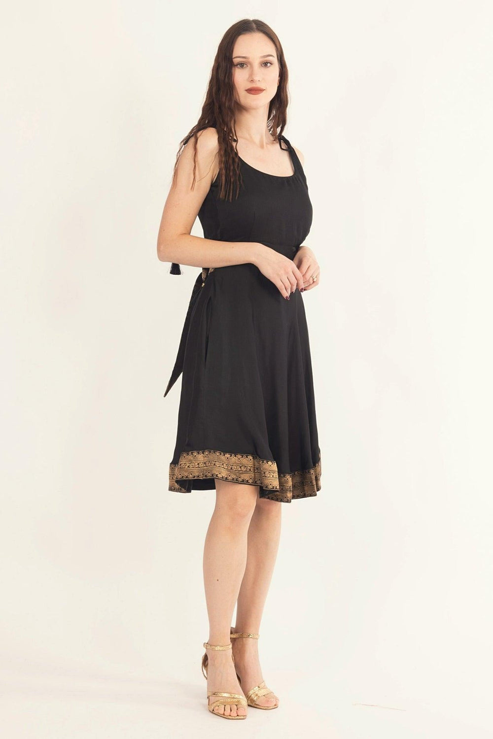 Black silk mini dress with Banarasi silk hem, golden back bow tie, and sleeveless design.