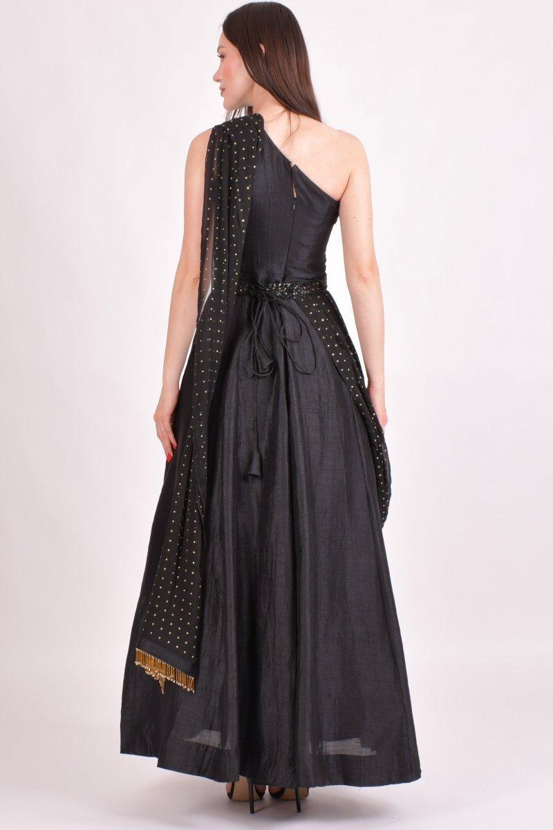 Black one-shoulder raw silk saree gown with intricate hand embroidery, mukaish work drape, and golden details.