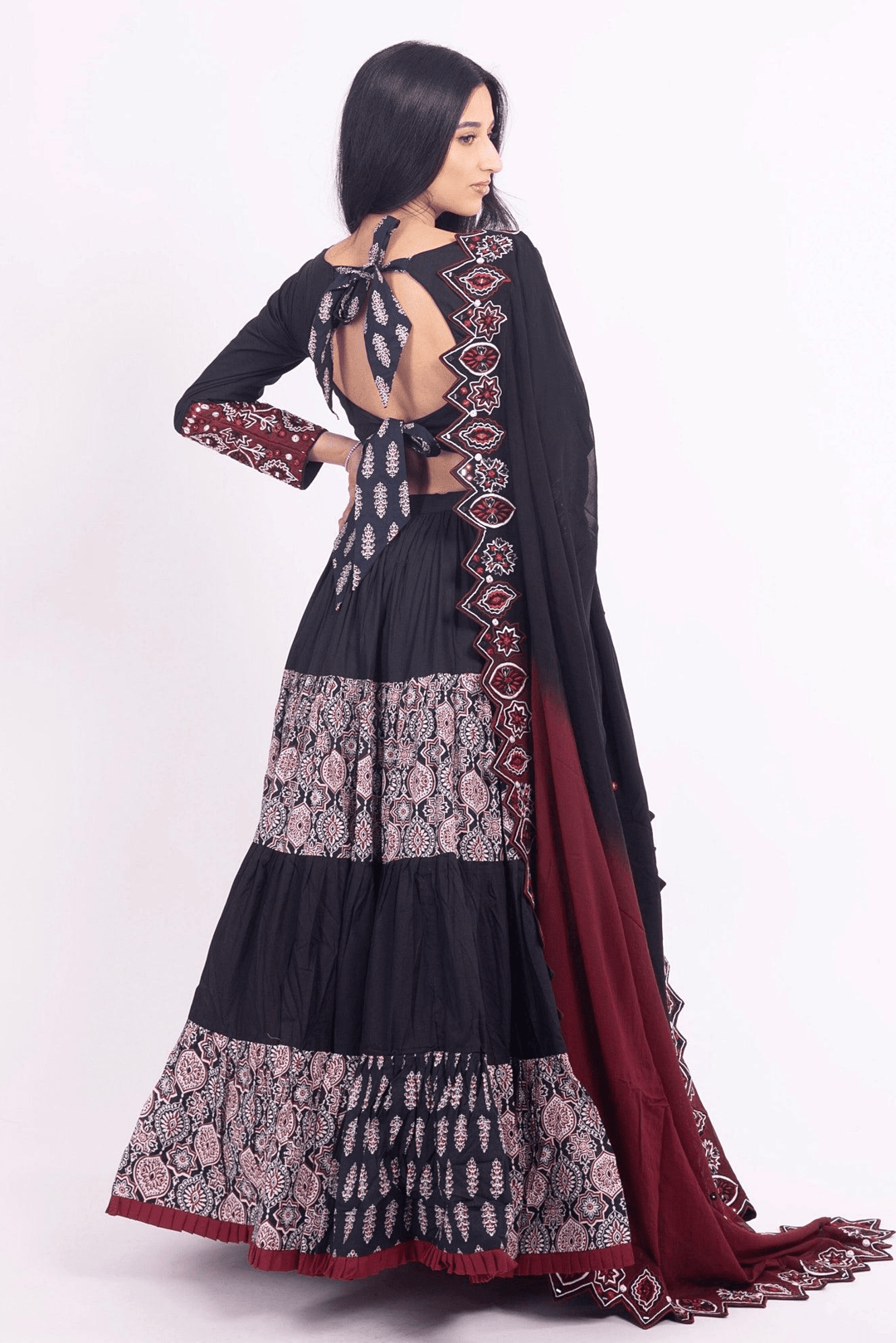 Black and red tiered silk lehenga choli with embroidered blouse and dupatta, perfect for Garba.