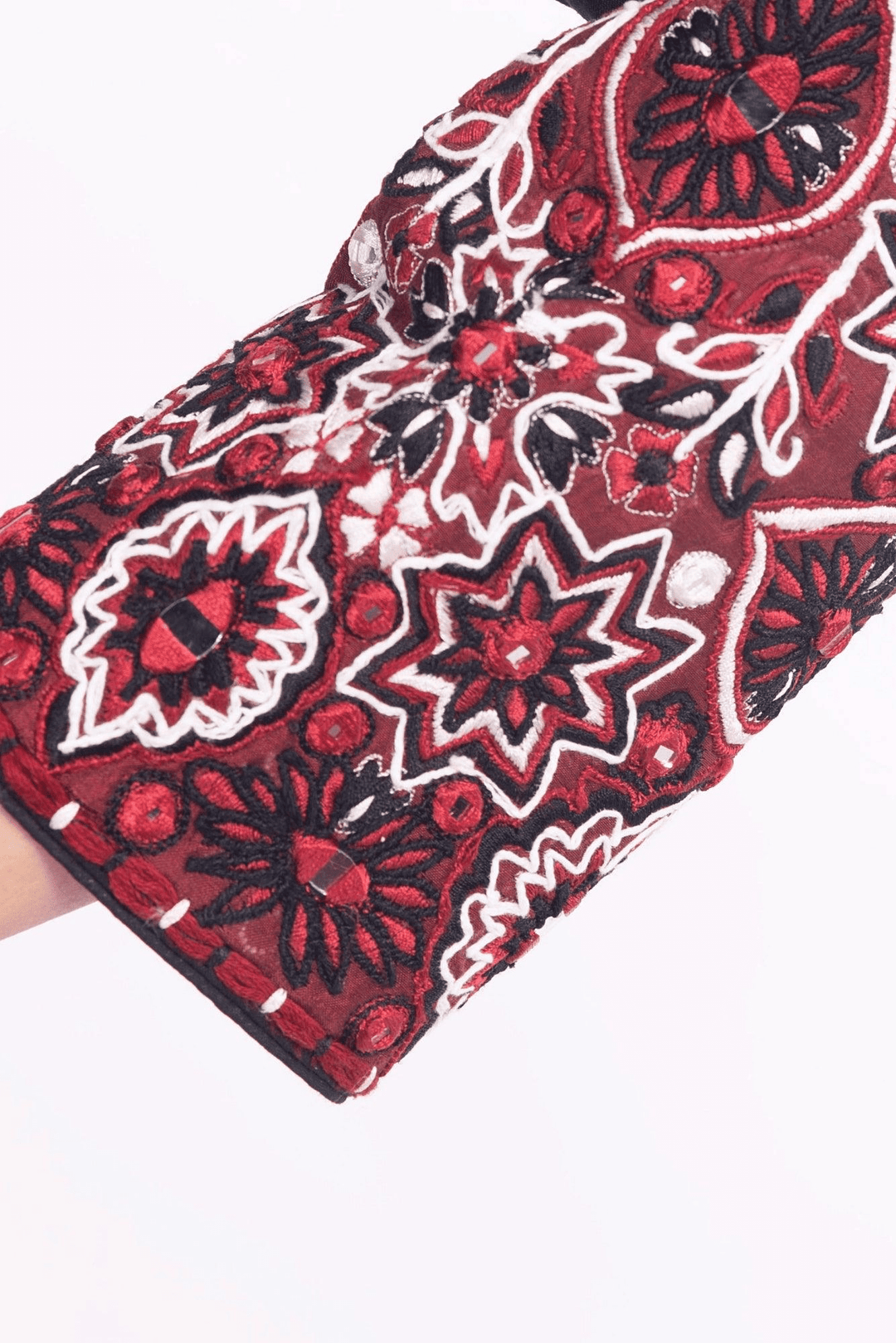 Close-up of a black and red embroidered silk blouse sleeve, perfect for Garba styles.