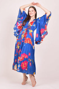 Blue printed chiffon maxi dress with angel sleeves, ruffle skirt, and lace-up tassel bodice.