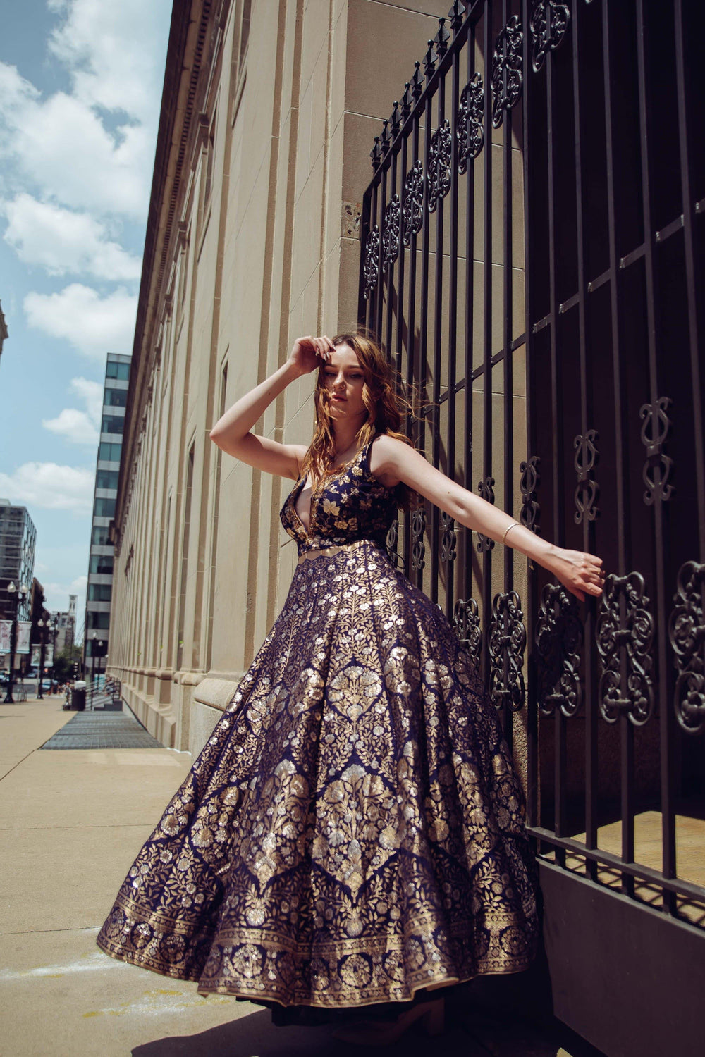 Blue Banarasi jacquard silk A-line gown with gold patterns, deep plunge, and hand-embroidered neckline.