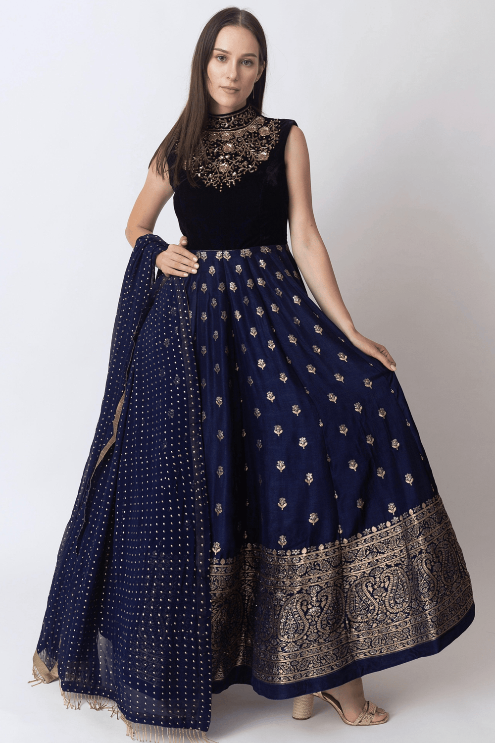 Blue gown with velvet hand-embroidered torso, Banarasi Jacquard hem, and matching mukaish work drape.