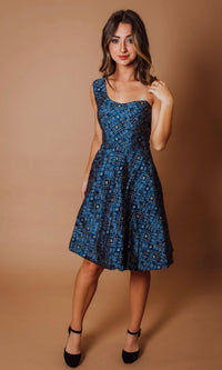 Blue silk one-shoulder midi dress with all-over bandhani print, worn by a woman.