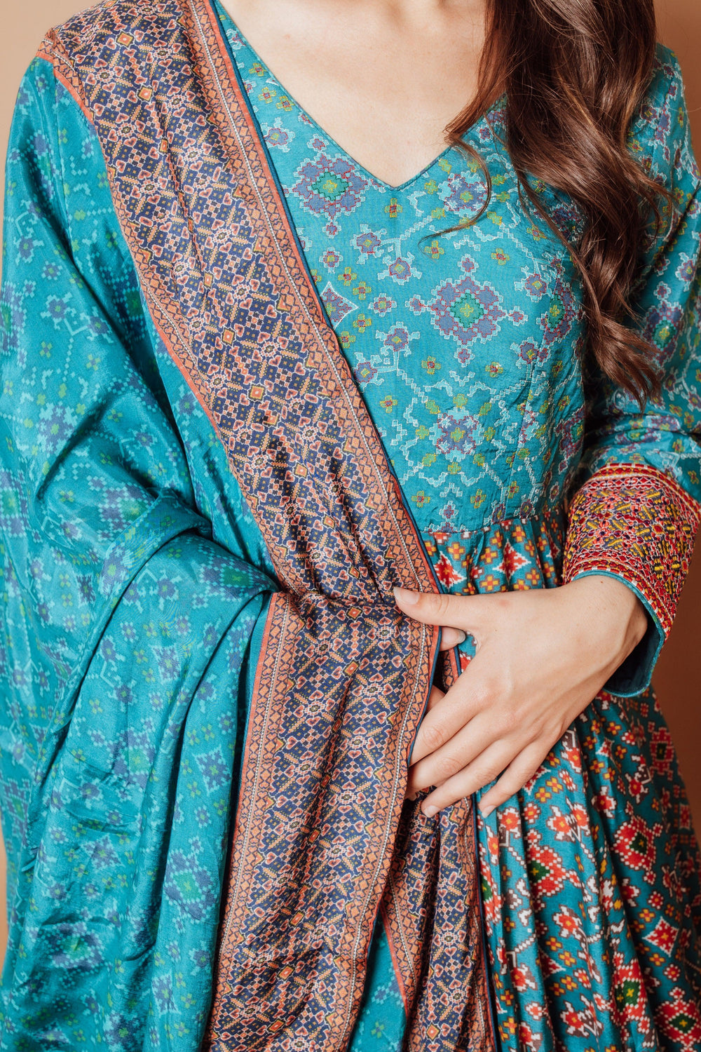 Blue silk patola print gown with intricate resham embroidery and an integrated drape.