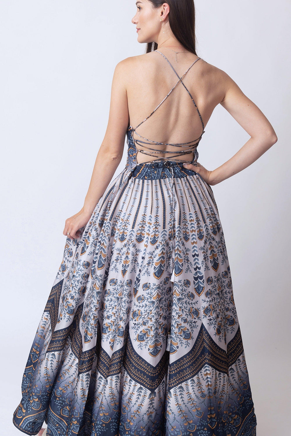 Blue silk V-neck printed maxi dress with criss-cross back straps and elegant all-over print.
