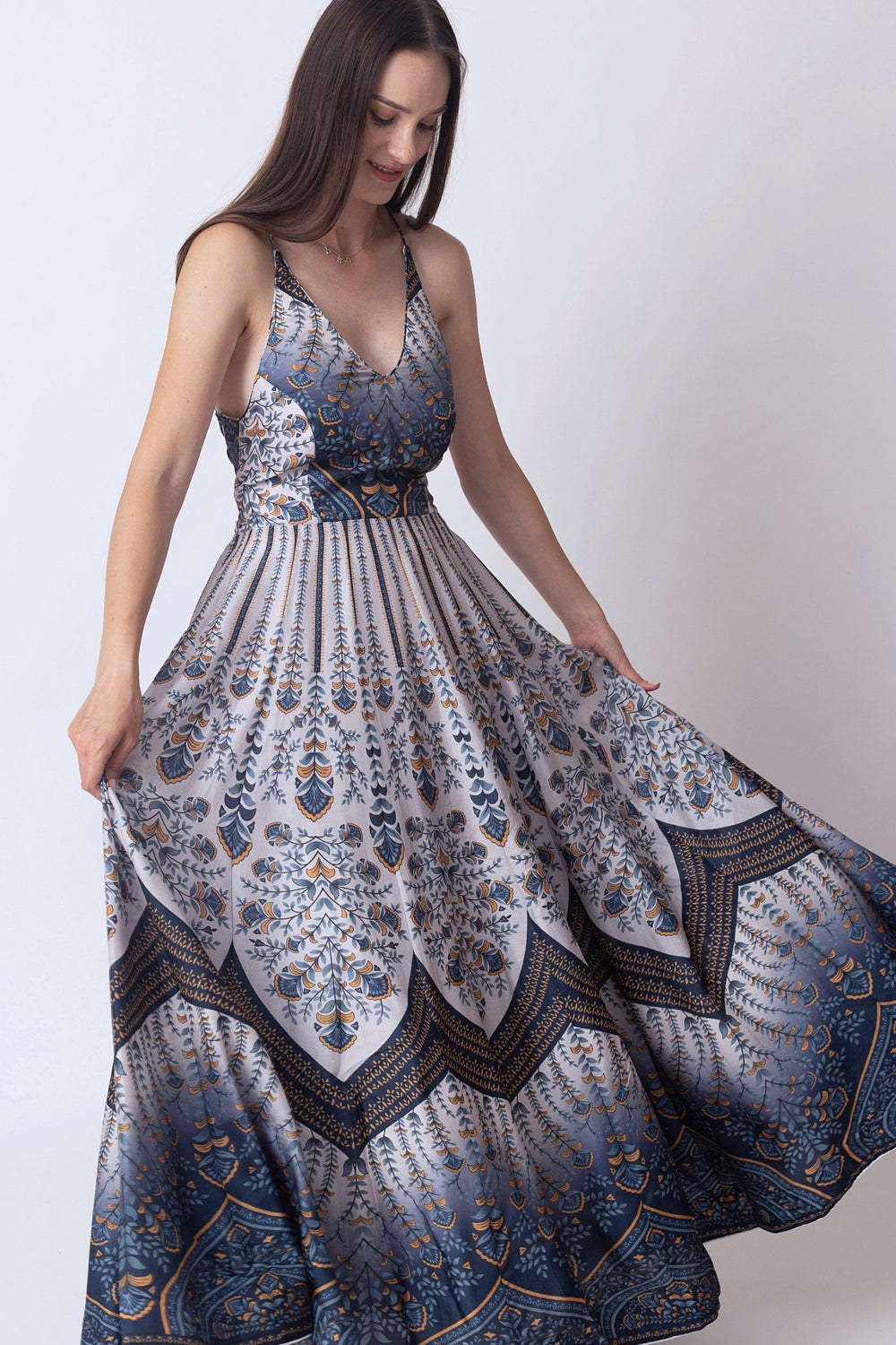 Blue V-neck silk maxi dress with elegant all-over print, sleeveless design, and flowing skirt.