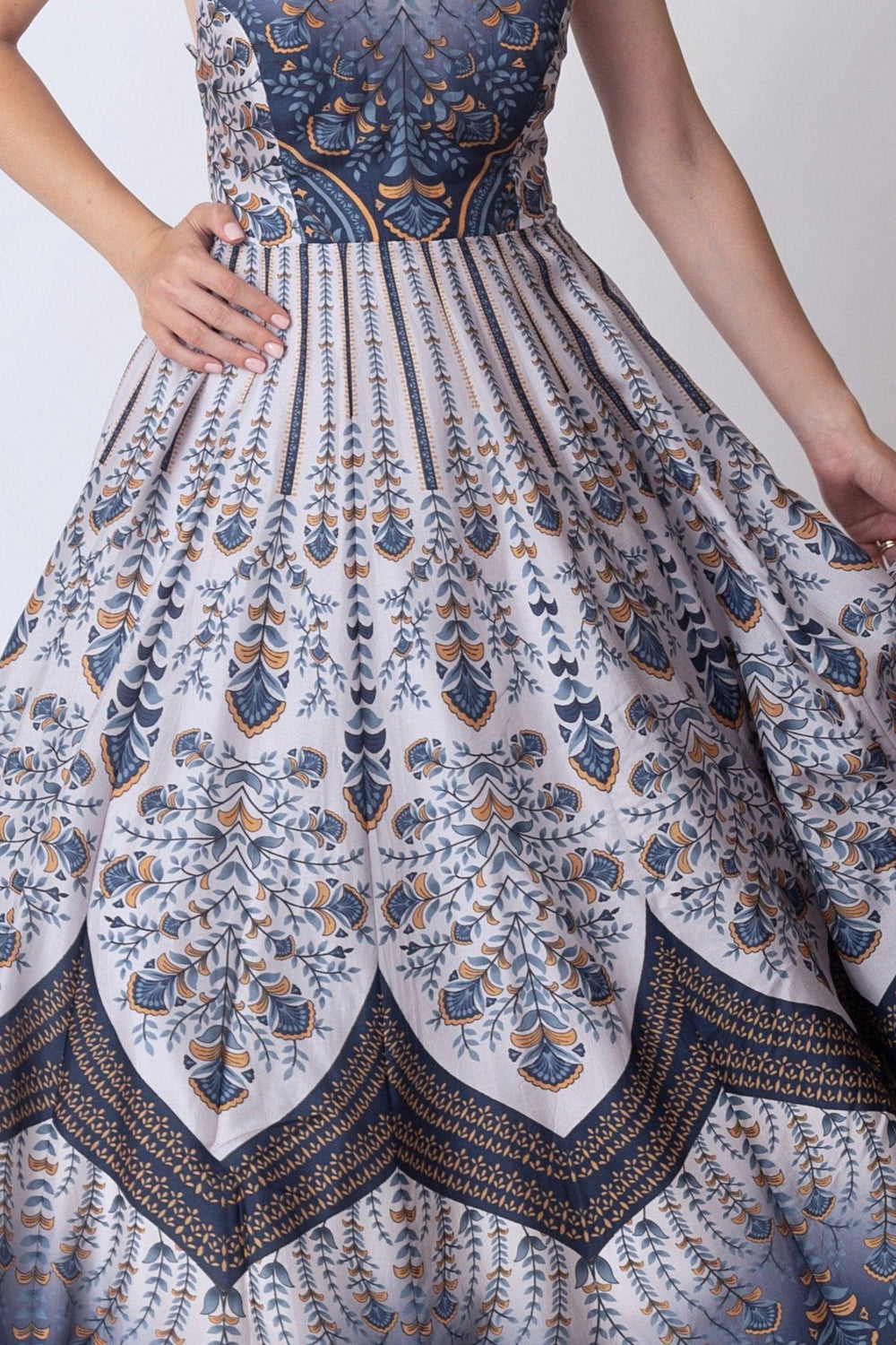 Blue V-neck silk dress with elegant all-over print, sleeveless design, and full skirt.
