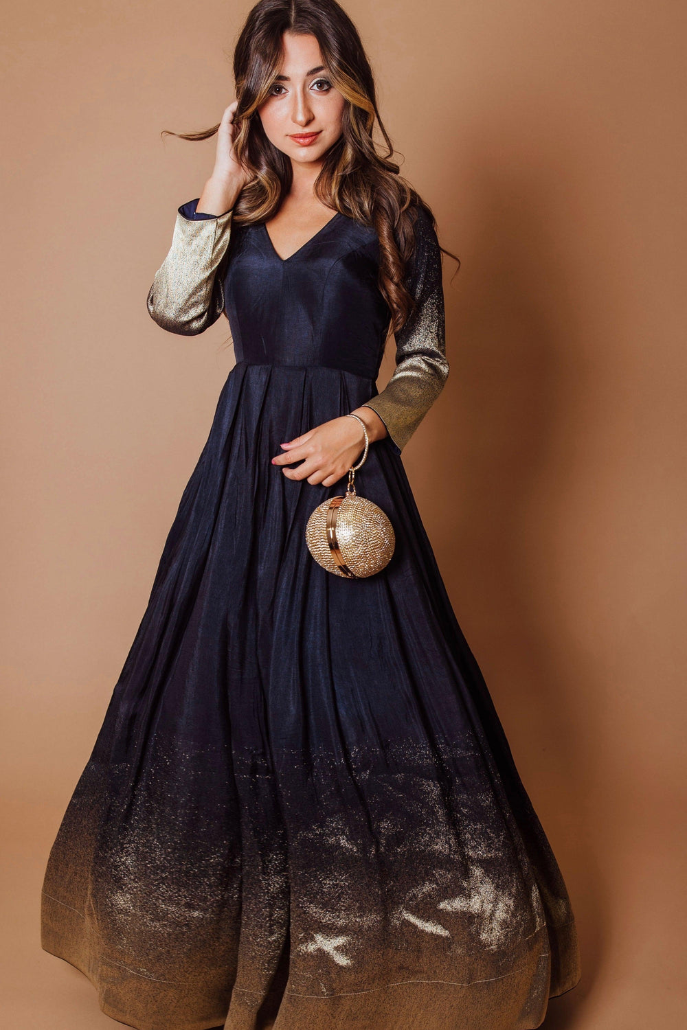 Navy blue silk long-sleeve dress with a golden border and matching clutch.