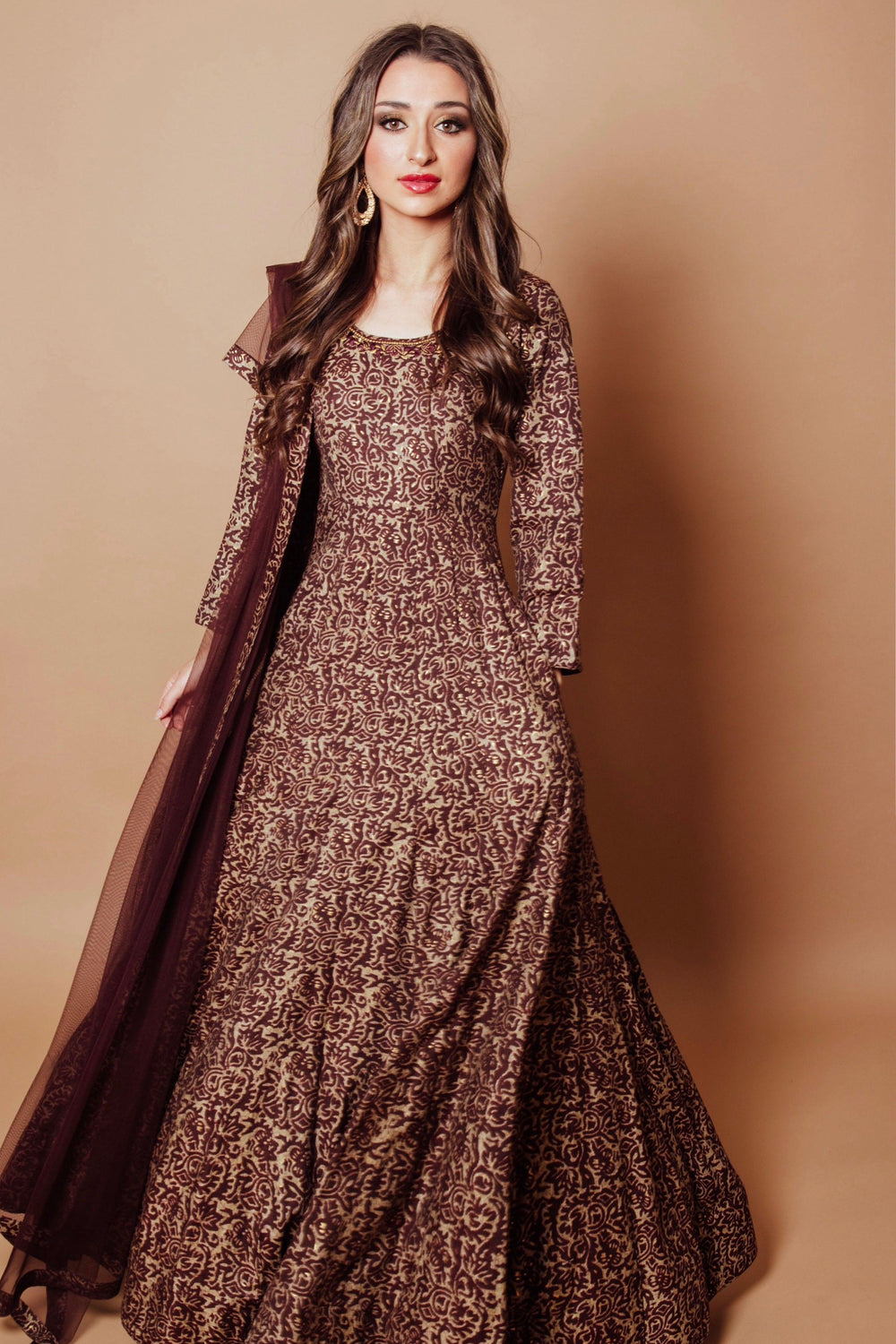 Brown A-line gown with gold scrolling vine embroidery, paired with a deep wine sheer net drape.