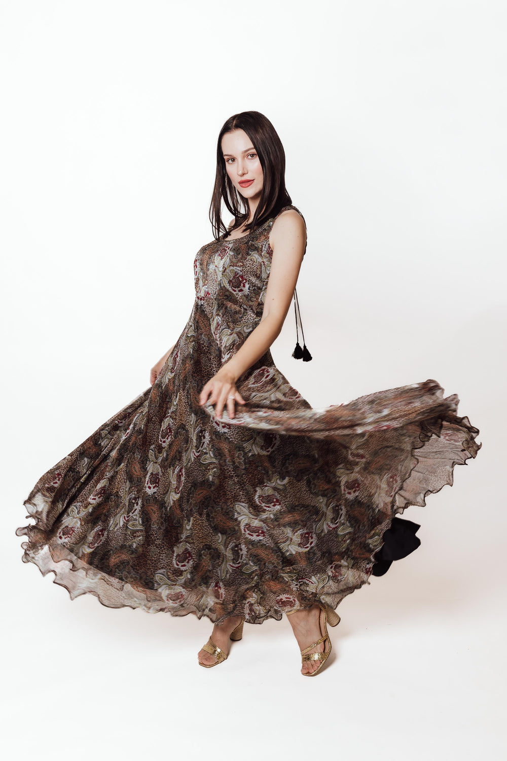 Brown chiffon maxi dress with botanical paisley print, scoop neck, open back, and ruffle hem.