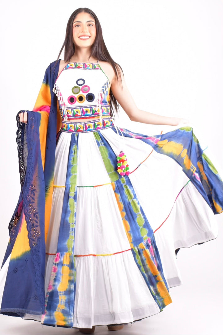 Cotton tie-dye Chaniya Choli with mirror-work blouse, tiered skirt, and pom-poms, ideal for Garba.