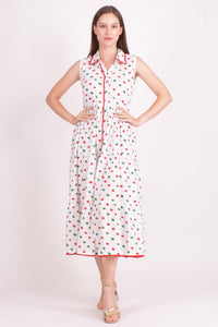 White cotton tiered midi dress with red and green dots, front buttons, and pom-pom trim.