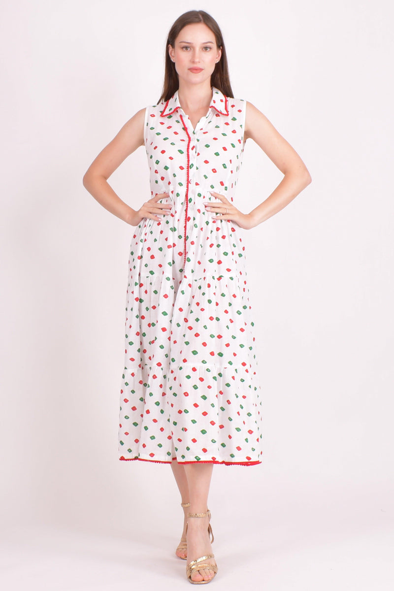 White cotton tiered midi dress with red and green dots, front buttons, and pom-pom trim.