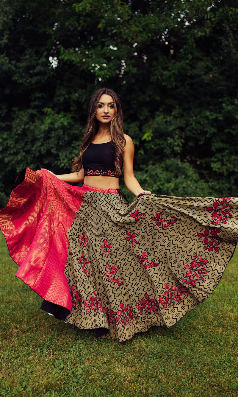 Woman in embroidered multicolor cotton-silk chaniya choli, twirling the skirt to show its vibrant design.