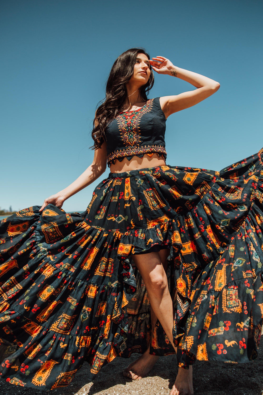 Embroidered navy high-low skirt set with a silk crop top and a matching printed skirt.