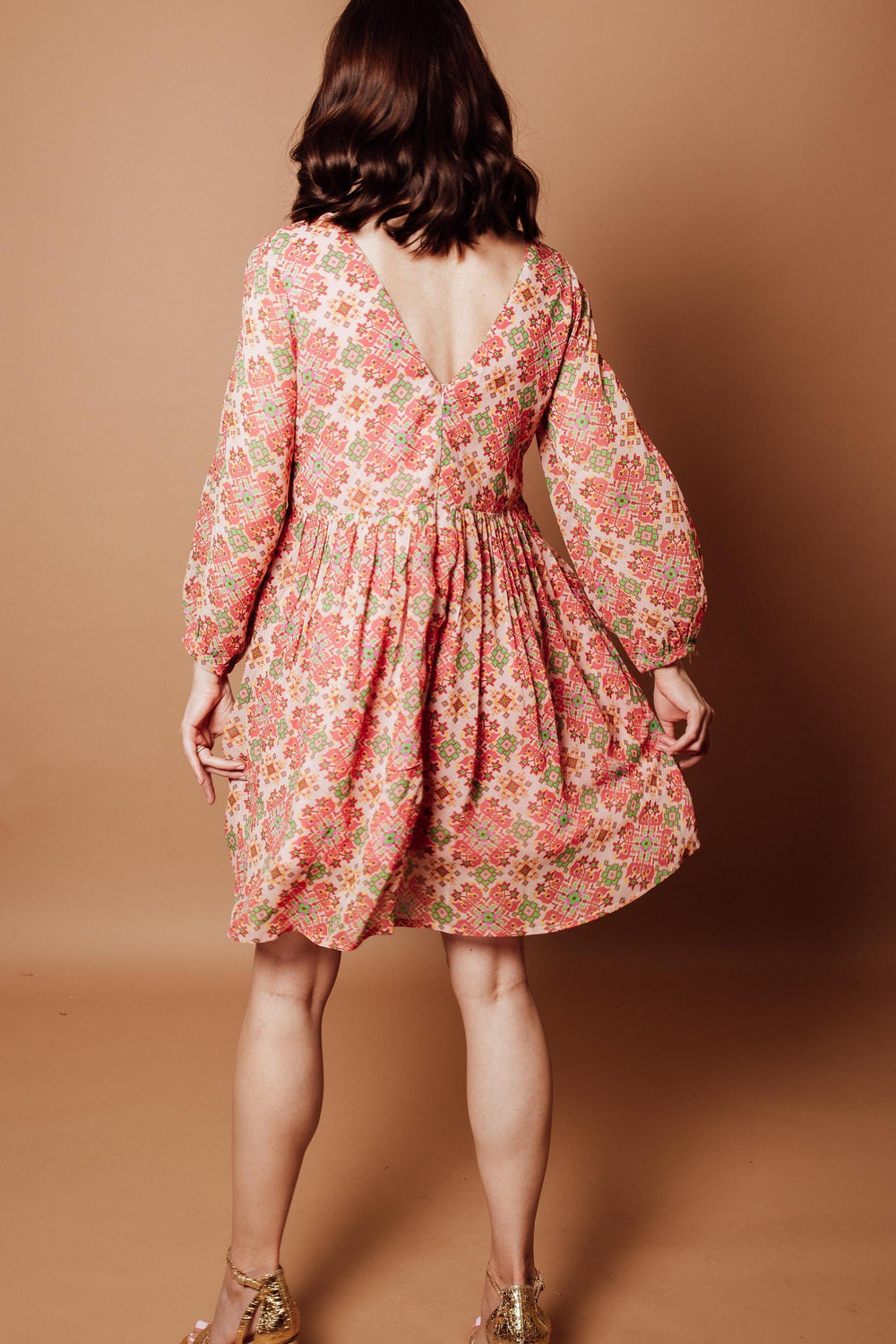 Floral Georgette V-Neck Mini Dress in coral, pink, and sage geometric print with long sleeves and pleated skirt.