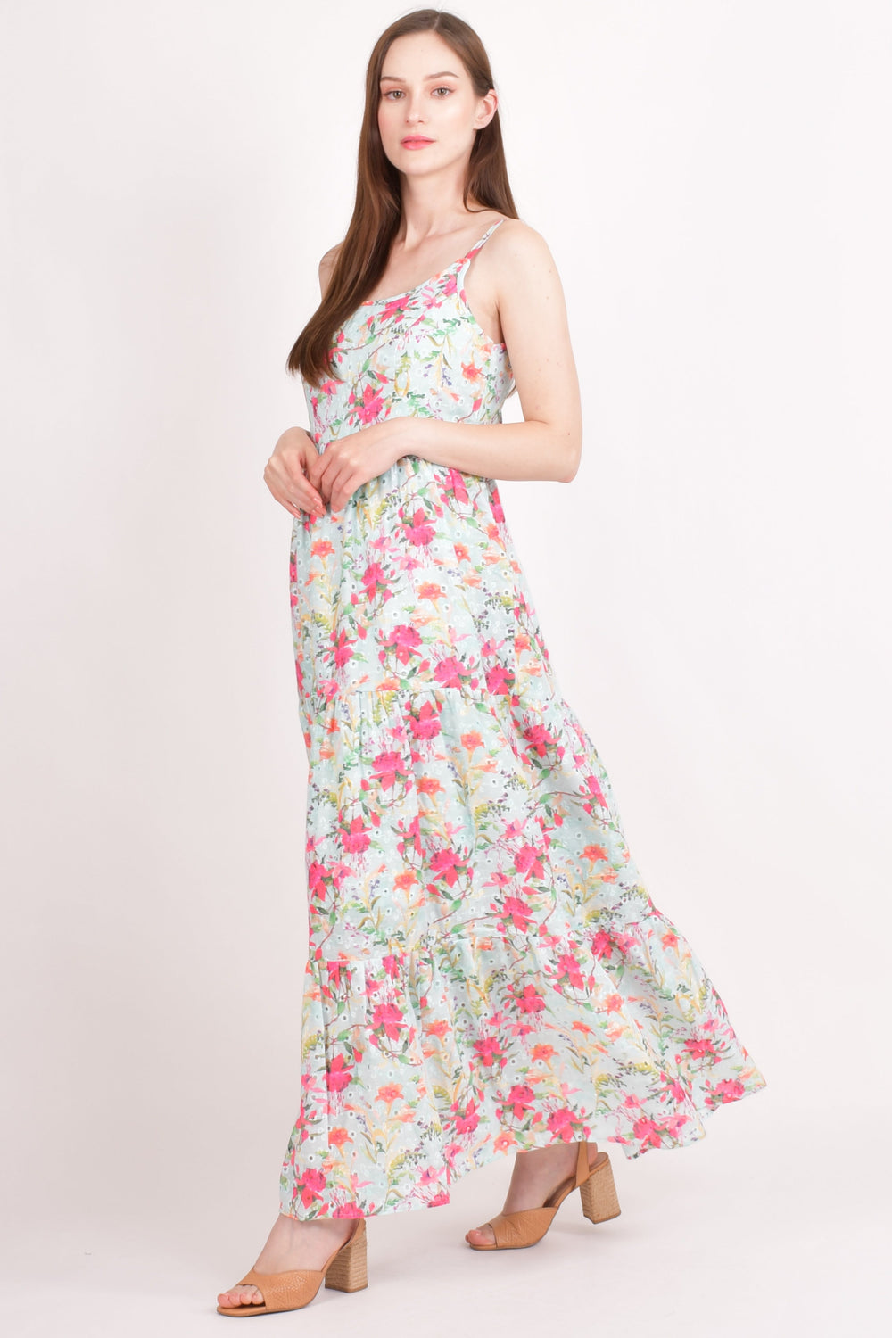 Model wears a light blue hakoba cotton tiered maxi dress with all-over pink and green floral embroidery.
