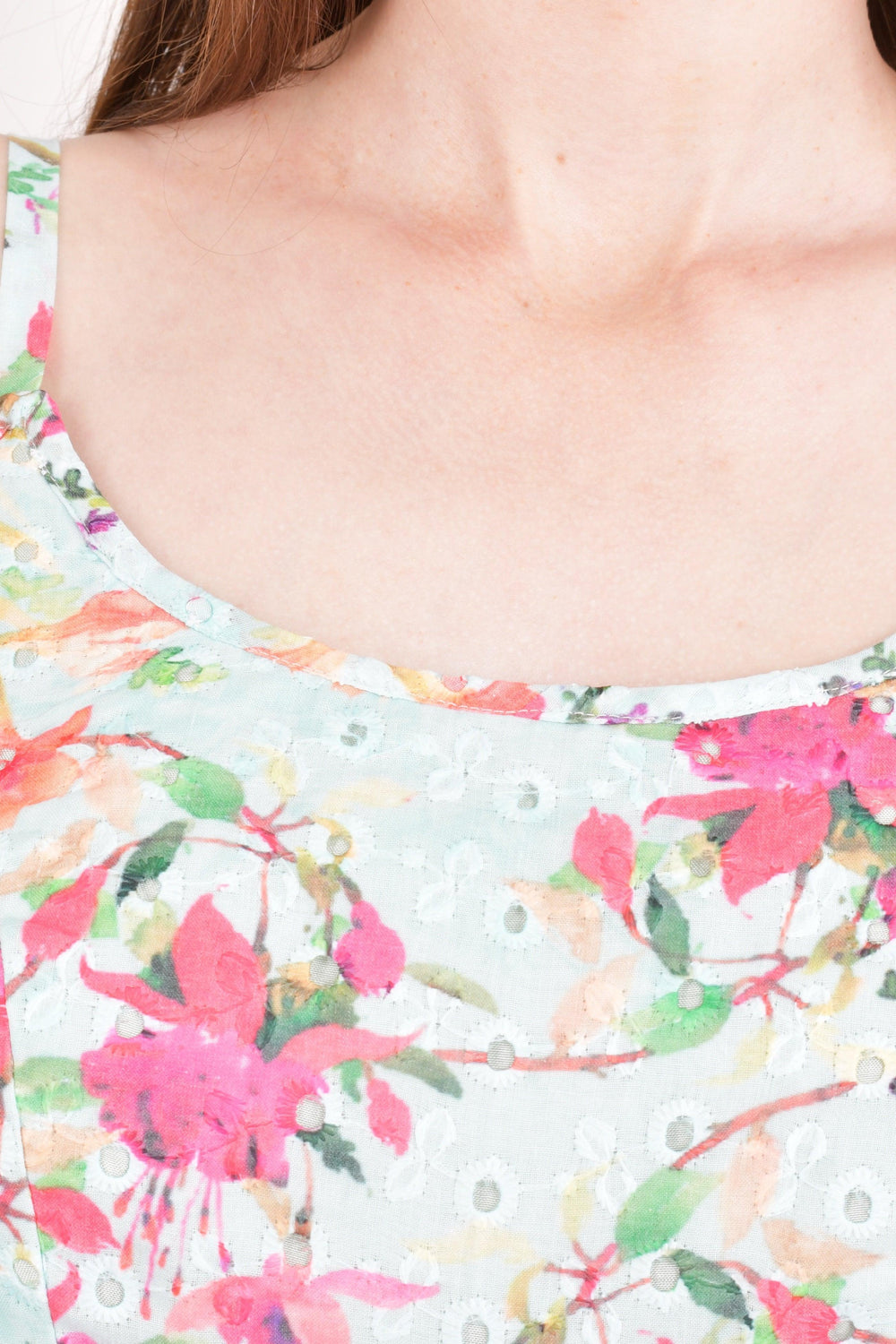 Close-up of a light blue hakoba cotton dress with all-over eyelet embroidery and vibrant floral motifs.