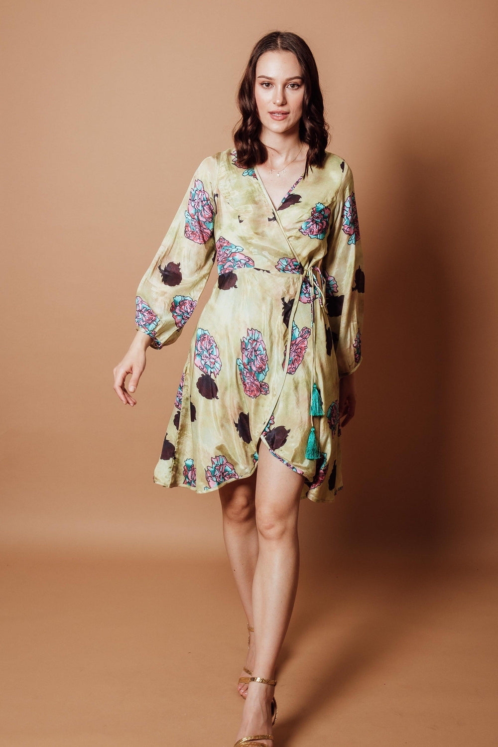 Green silk wrap dress with colorful floral patterns, full sleeves, and side closure.