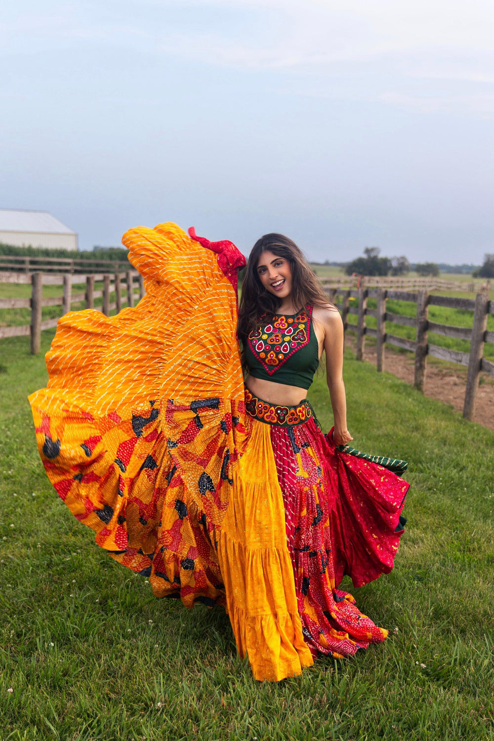 Woman in a full flare multicolor cotton Chaniya Choli with a green embroidered top, dramatically twirling.