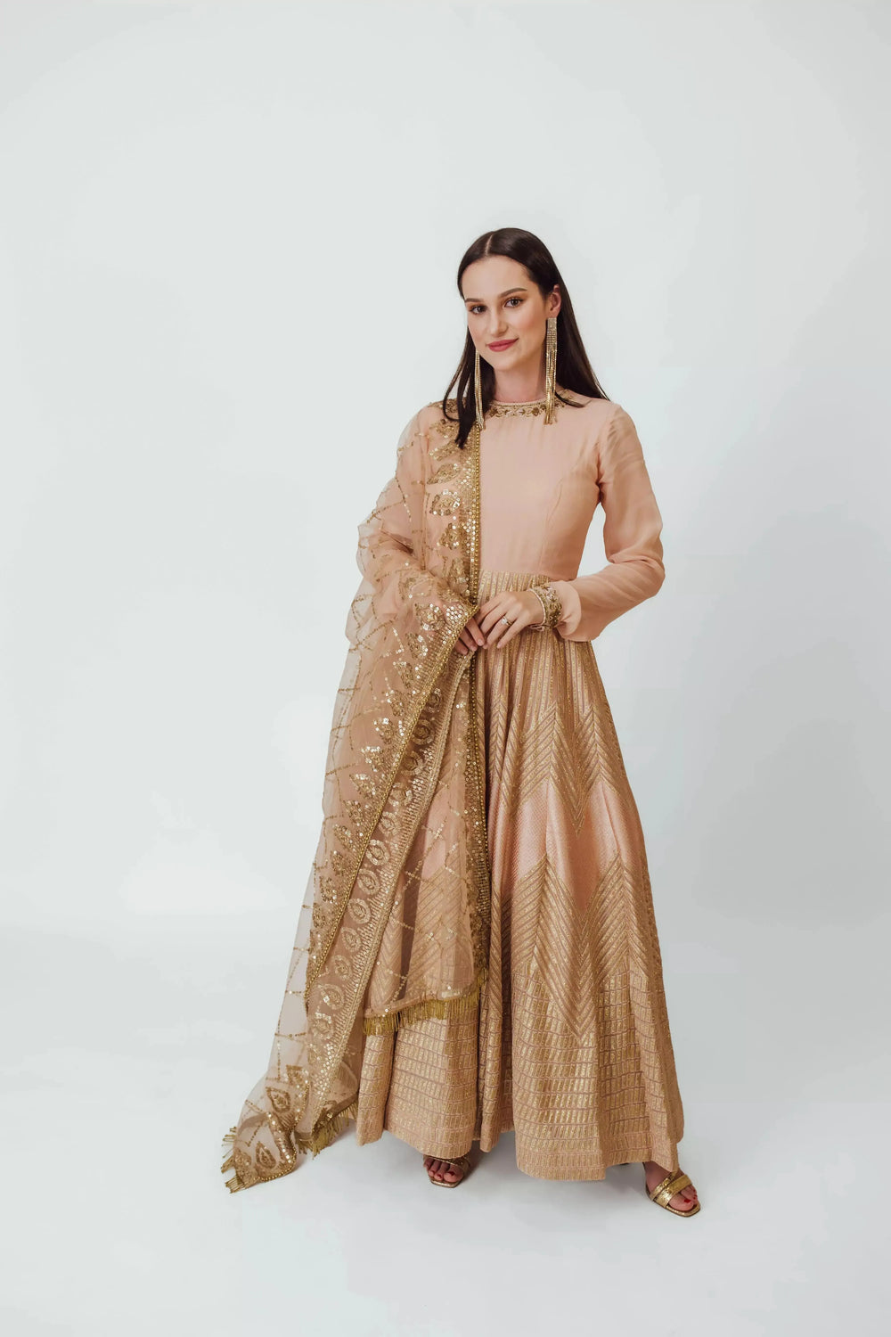 Dusty peach georgette full sleeve gown with gold embroidery, paired with a sequined net drape.