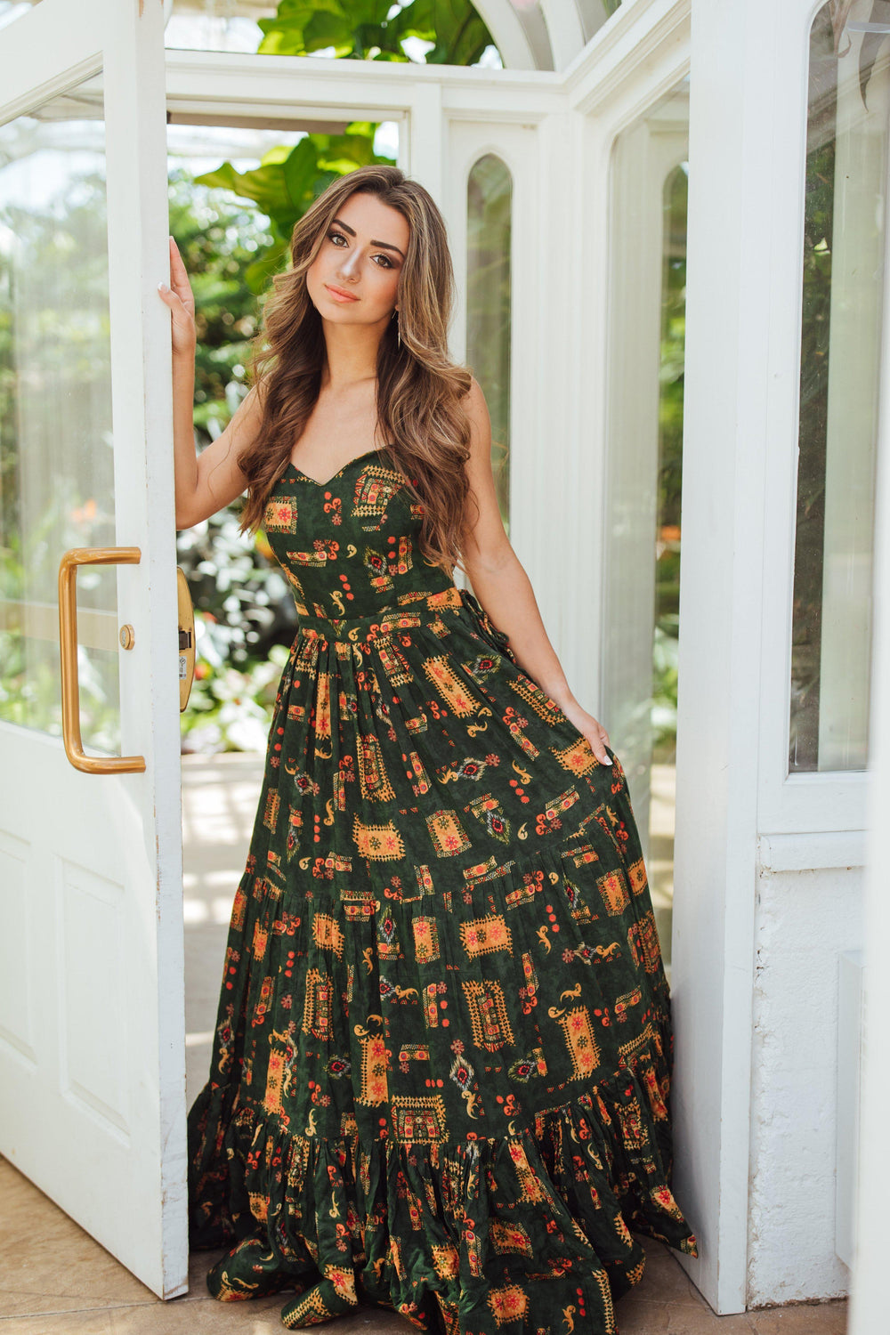 Green rayon convertible maxi gown with ethnic motif print, sweetheart bodice, cinched waist, and tiered skirt.