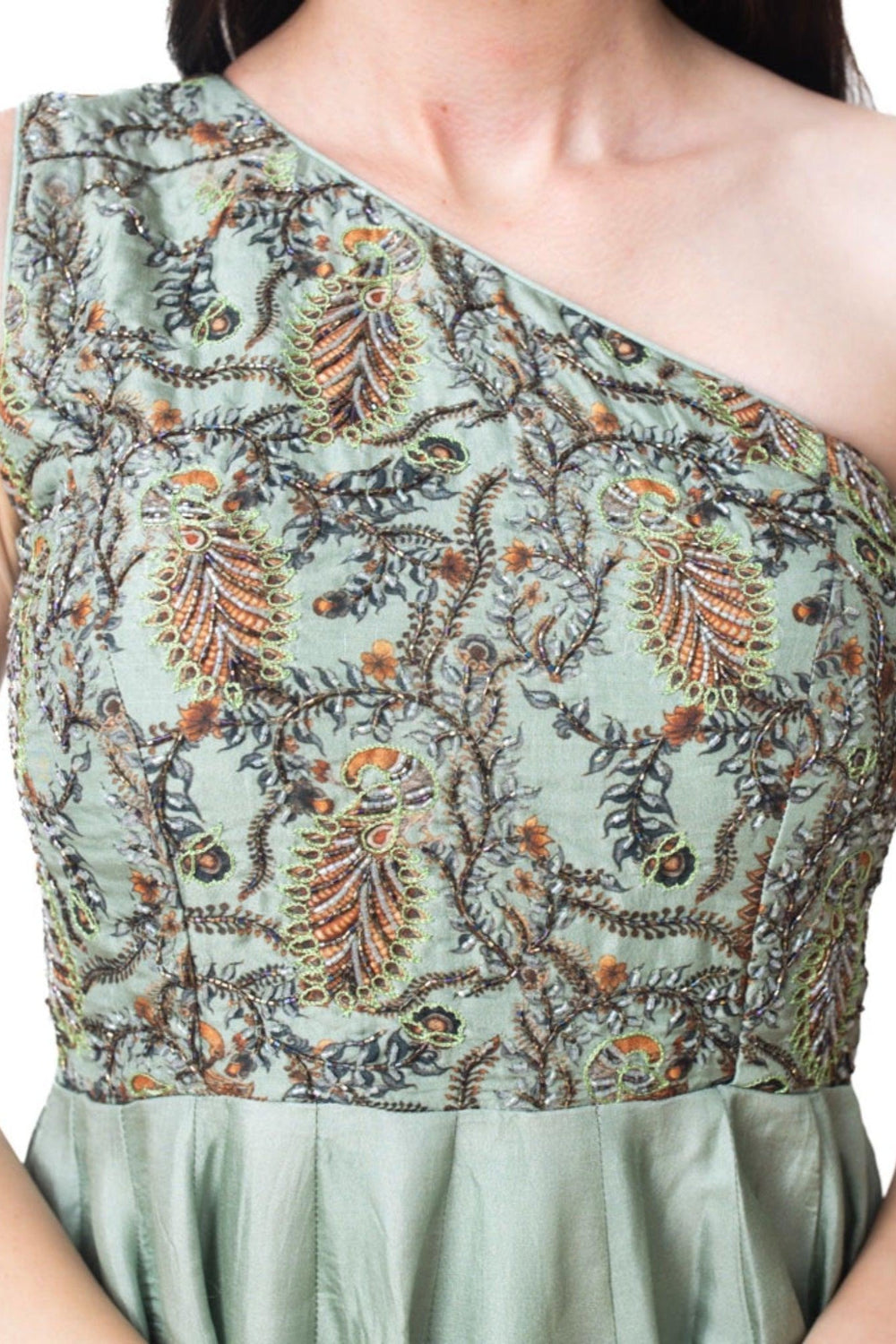 Close-up of a green floral hand-embroidered one-shoulder gown with intricate beadwork on the torso.