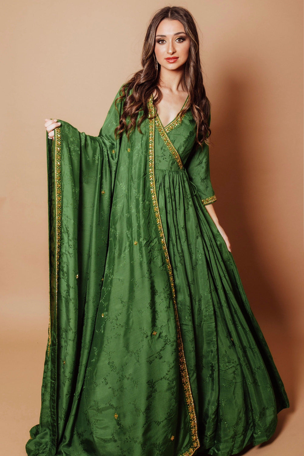 Emerald green silk anarkali gown with tonal floral embroidery, gold cutdana, stones, and sequins.