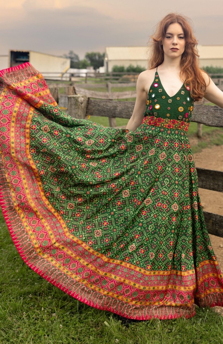 Green silk open-back halter gown with hand-embroidered torso and patola patterns.