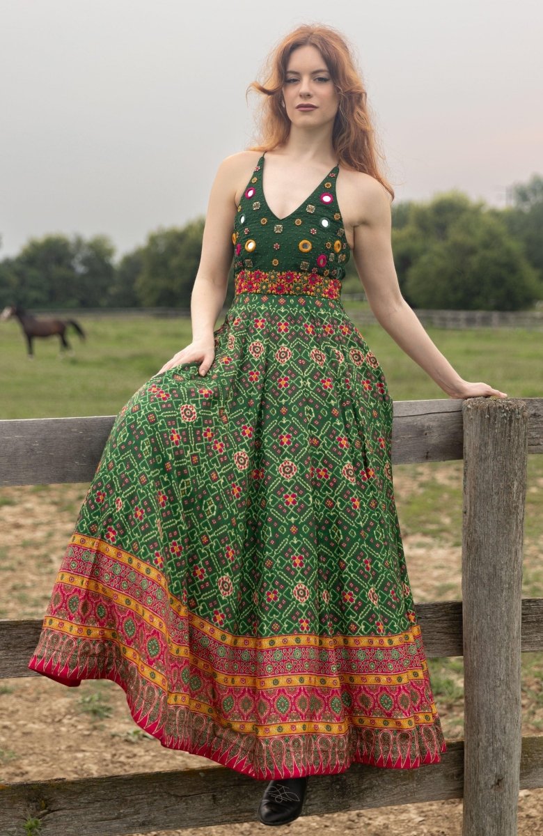 Green silk halter gown with hand-embroidered torso, patola patterns, and open back.