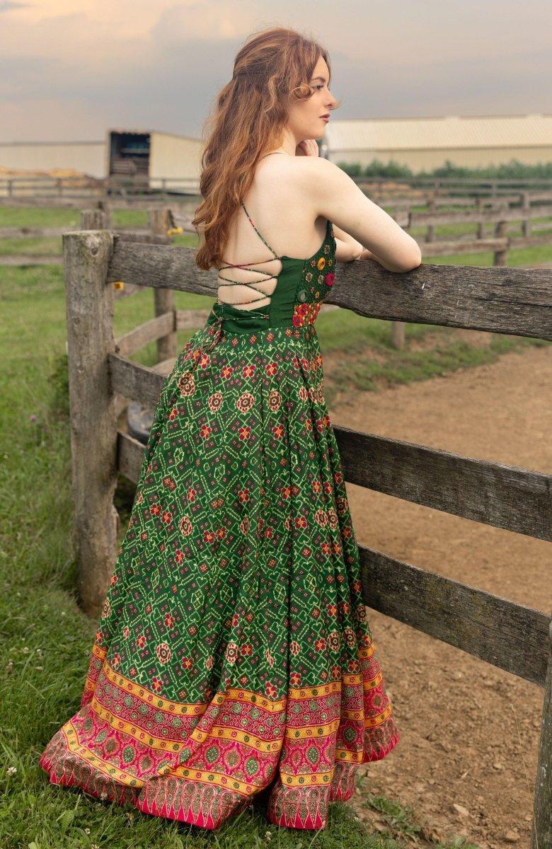 Green silk open-back halter gown with hand-embroidered torso and patola patterns.