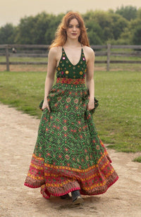 Green silk halter dress with hand-embroidered torso, patola patterns, and open back.