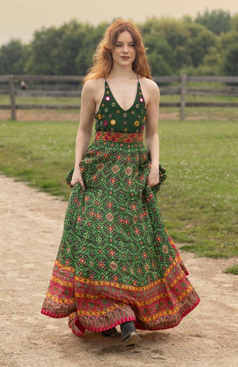 Green silk halter dress with hand-embroidered torso, patola patterns, and open back.