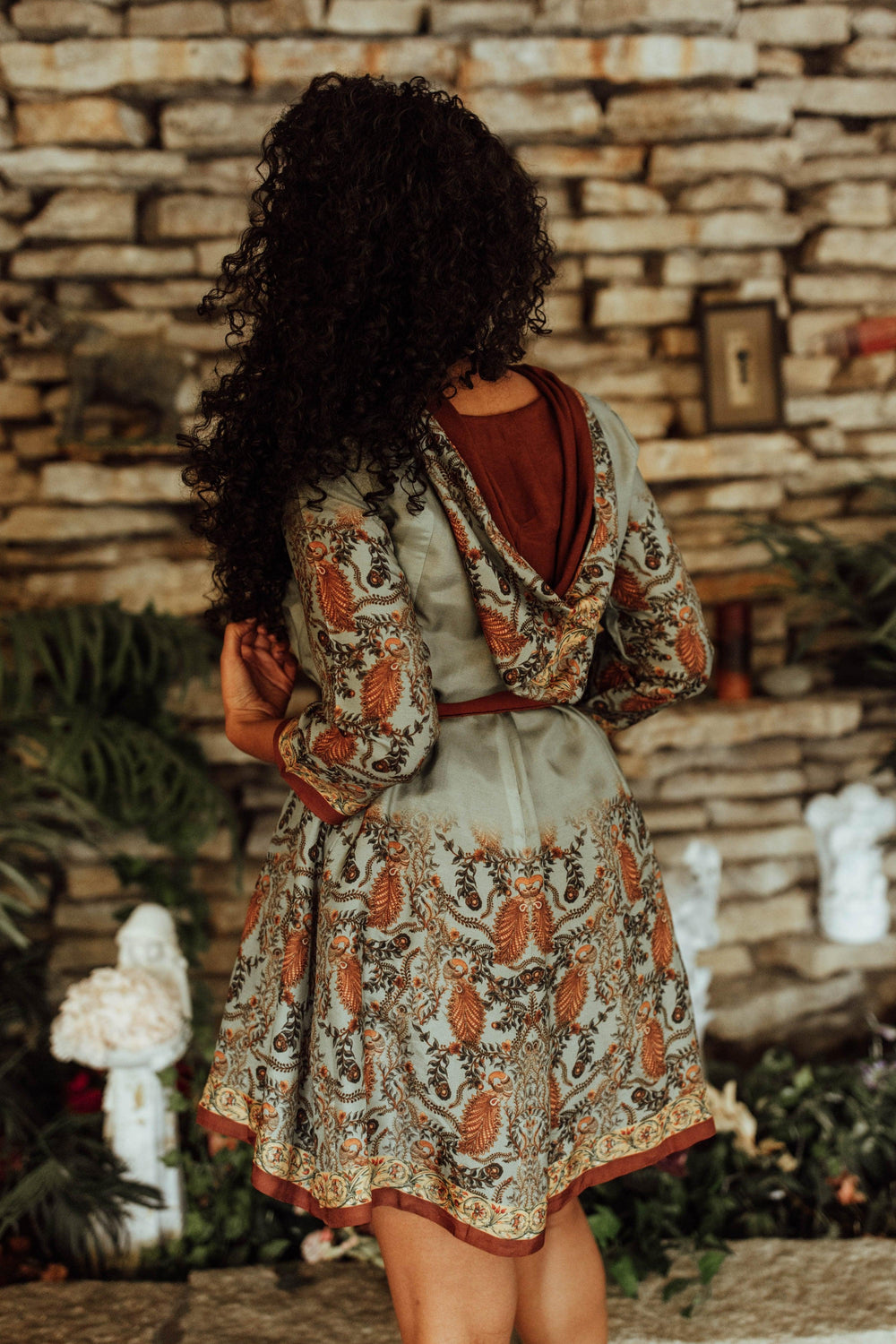 Pista green silk hoodie mini dress with intricate print, full sleeves, and matching belt.